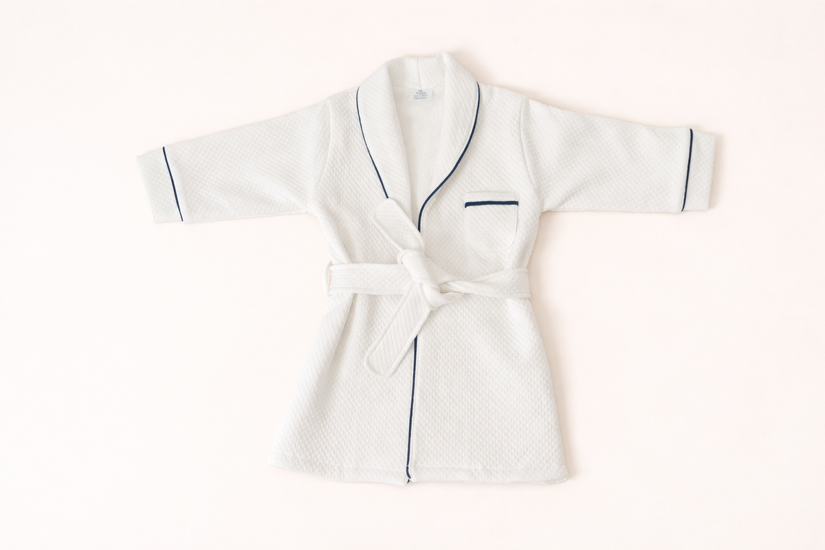 White quilted Pima cotton kids bathrobe with navy piping by Pipa & Pierre