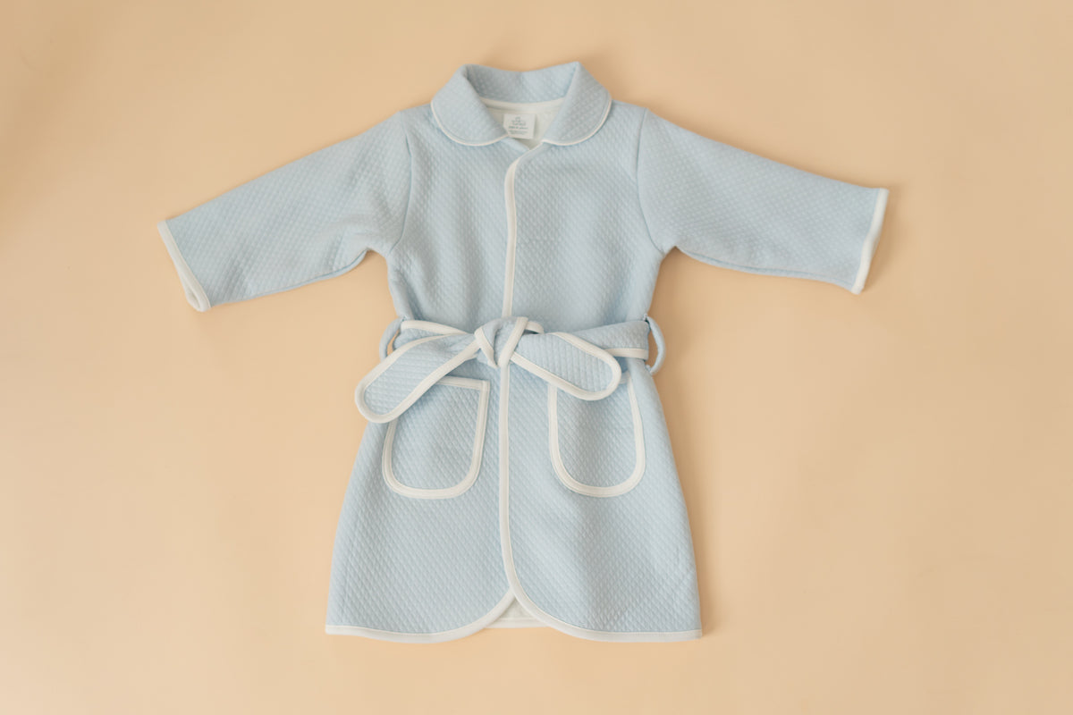 Blue quilted kids bathrobe with white piping by Pipa & Pierre